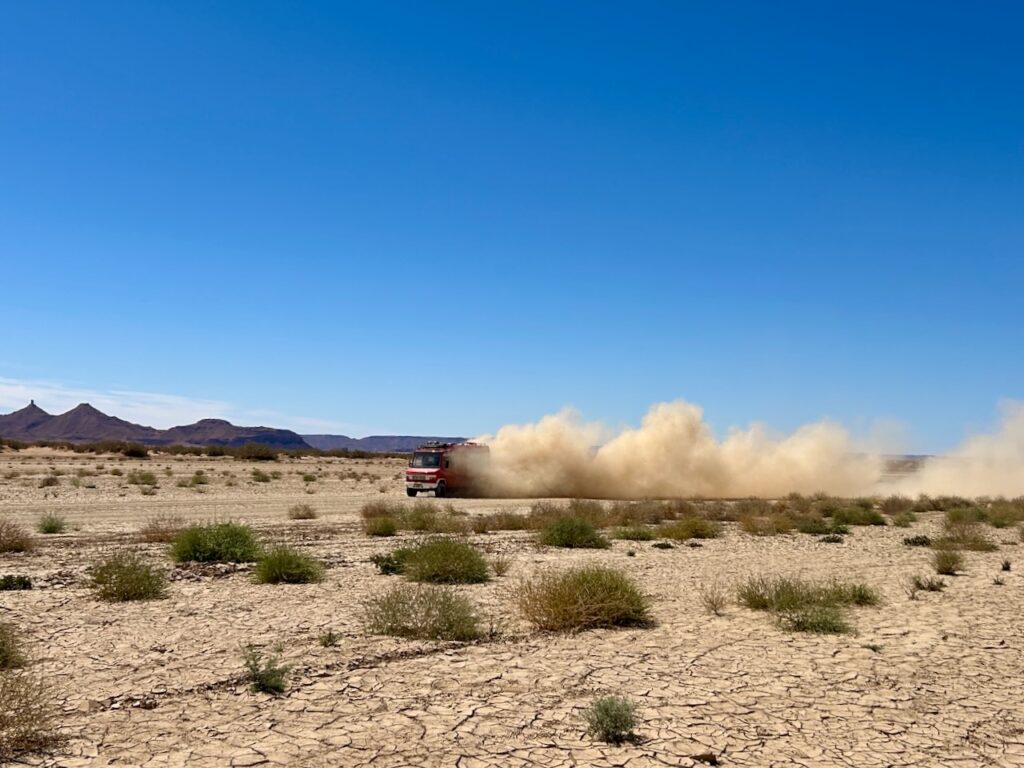 offroad camper met grote stofwolk erachter